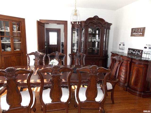 dining area featuring hardwood / wood-style floors and a chandelier