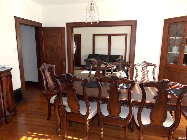 dining room with a chandelier and dark wood-type flooring