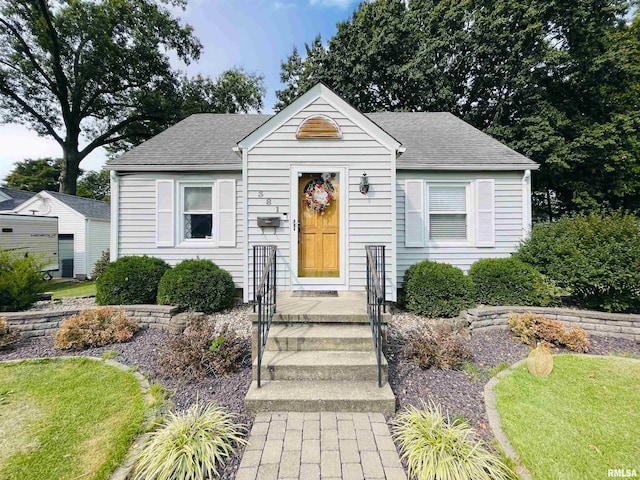 bungalow-style house featuring a front lawn