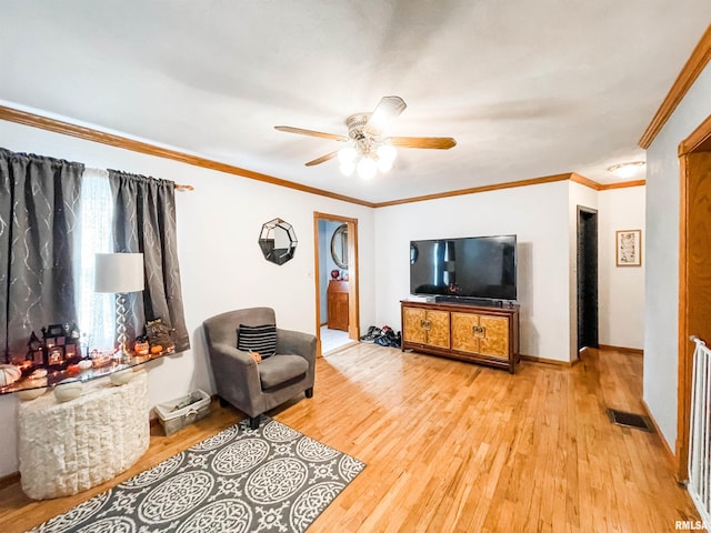 living room featuring ornamental molding, light hardwood / wood-style floors, and ceiling fan