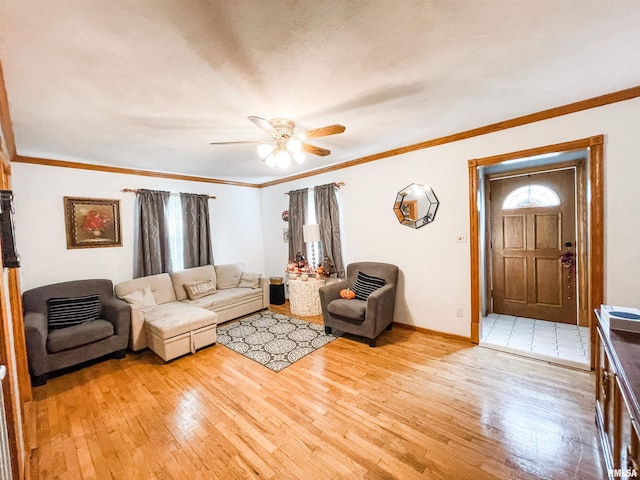 living room with ceiling fan, light wood-type flooring, and ornamental molding