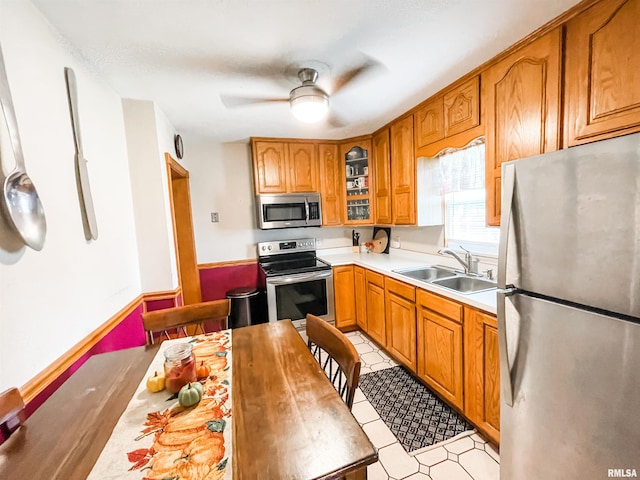 kitchen featuring light tile patterned floors, sink, ceiling fan, and stainless steel appliances