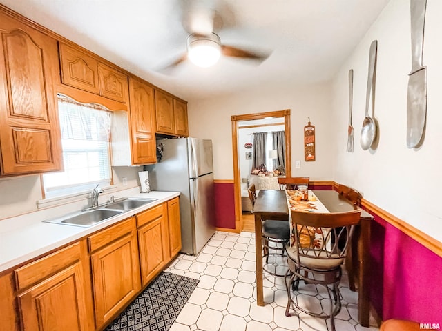 kitchen featuring ceiling fan, stainless steel refrigerator, and sink