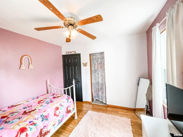 bedroom with light wood-type flooring, ceiling fan, and multiple windows