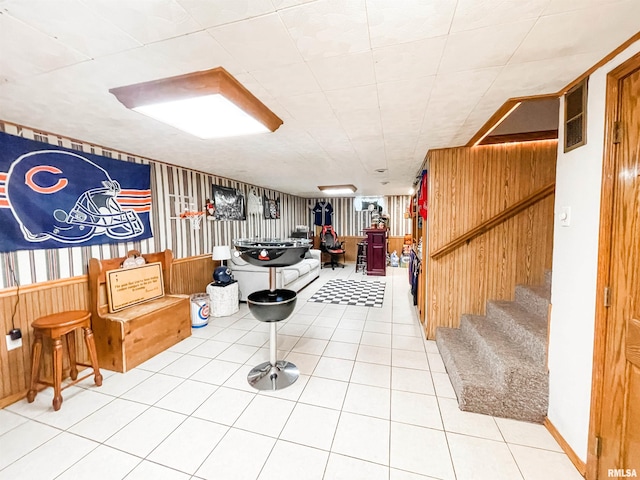 basement featuring tile patterned flooring and wooden walls