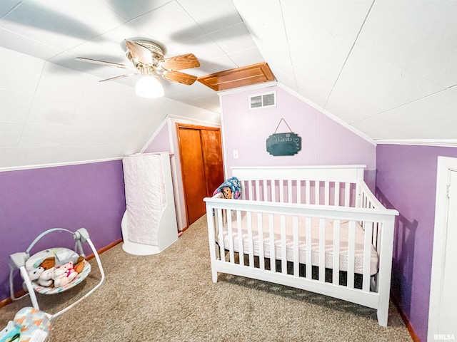 carpeted bedroom featuring vaulted ceiling, ceiling fan, and a nursery area