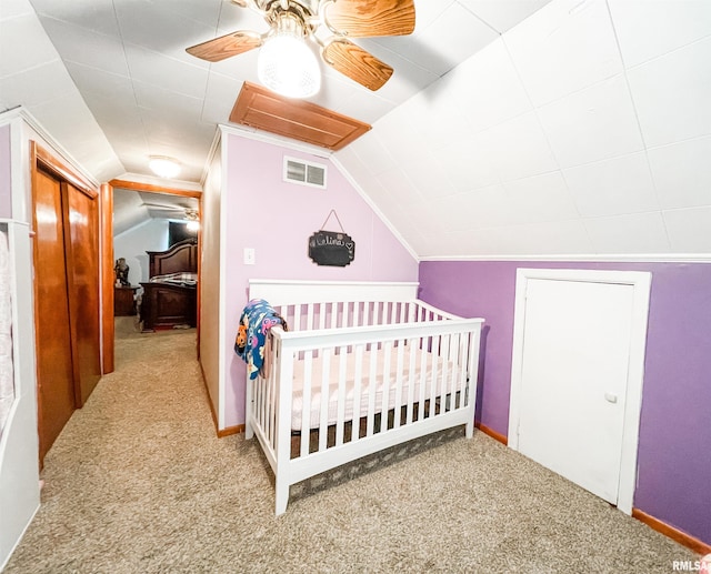 bedroom featuring light carpet, ceiling fan, and a nursery area