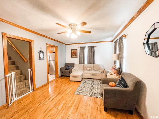 living room with ceiling fan, light hardwood / wood-style flooring, and crown molding