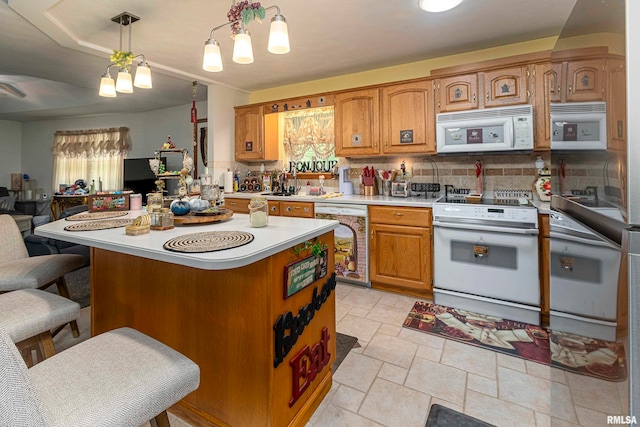 kitchen with pendant lighting, white appliances, a center island, a kitchen bar, and decorative backsplash