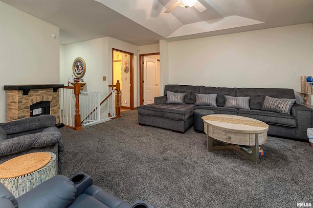 living room with a stone fireplace, carpet flooring, lofted ceiling, and ceiling fan