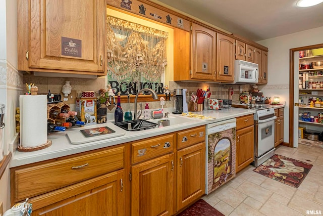 kitchen featuring white appliances, sink, and backsplash