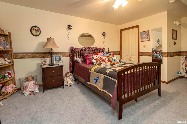 carpeted bedroom featuring ceiling fan and a closet