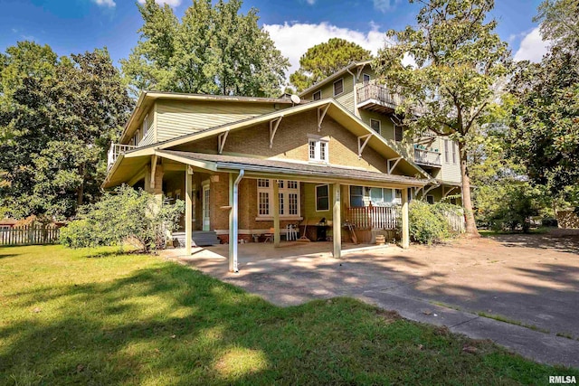 view of front of house featuring a balcony, a patio, and a front lawn