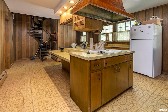 kitchen with white appliances, wooden walls, and a center island