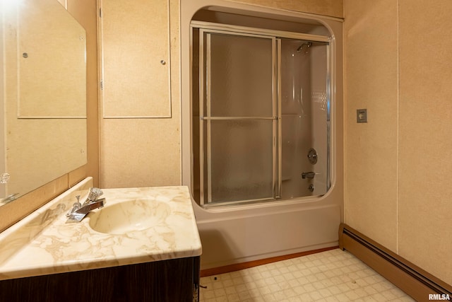 bathroom with combined bath / shower with glass door, vanity, and a baseboard heating unit