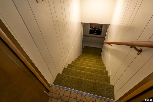 stairs featuring wooden walls