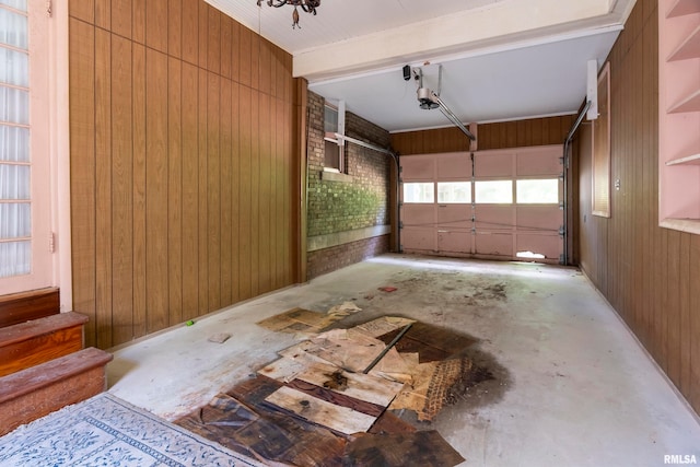 garage with a garage door opener and wooden walls