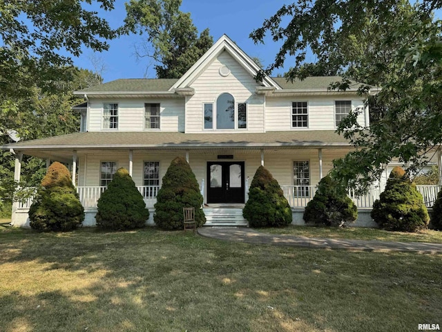 view of front facade with a porch, french doors, and a front lawn