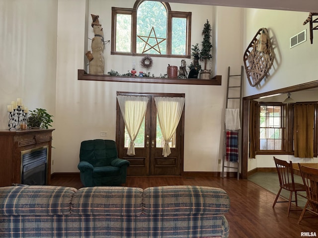 living room featuring a high ceiling, dark hardwood / wood-style floors, and french doors