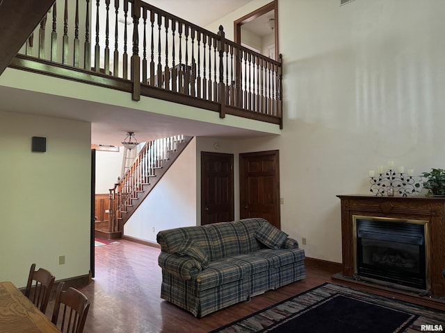 living room with hardwood / wood-style flooring and a towering ceiling