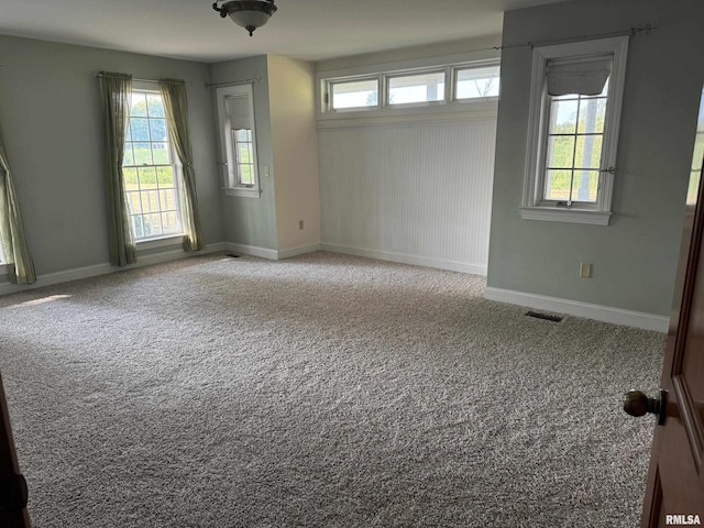 carpeted spare room featuring plenty of natural light