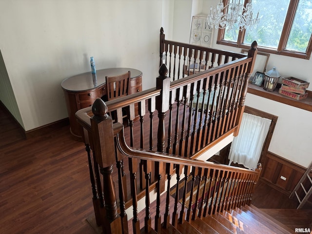 stairway featuring wood-type flooring and a chandelier