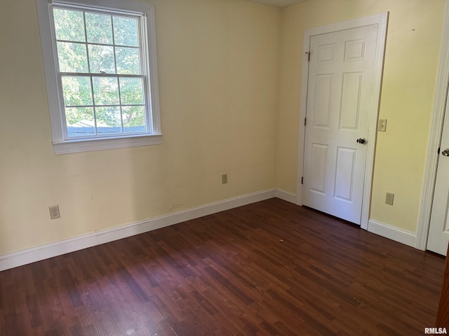 unfurnished room with dark hardwood / wood-style flooring