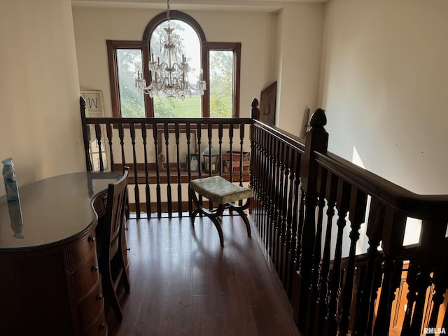 hallway with wood-type flooring and a chandelier