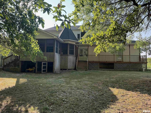 back of house featuring a sunroom, a yard, a deck, and french doors