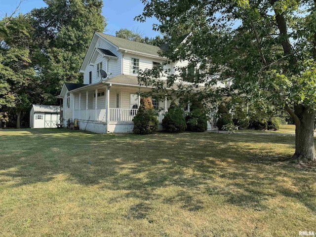 view of front facade featuring a porch, a front yard, and a storage unit