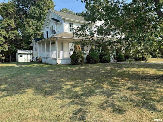 view of front of home with a storage shed, covered porch, and a front yard