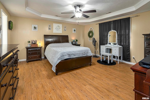 bedroom featuring ceiling fan, a tray ceiling, and light hardwood / wood-style flooring