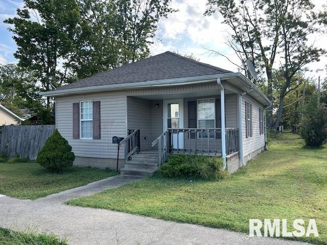 bungalow-style home with covered porch and a front lawn