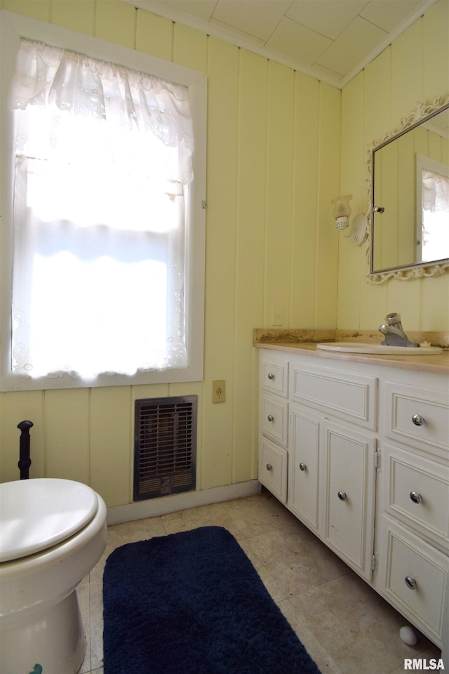 bathroom featuring vanity, toilet, heating unit, and tile patterned floors