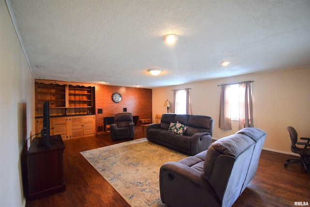 living room with a textured ceiling, dark hardwood / wood-style flooring, and brick wall