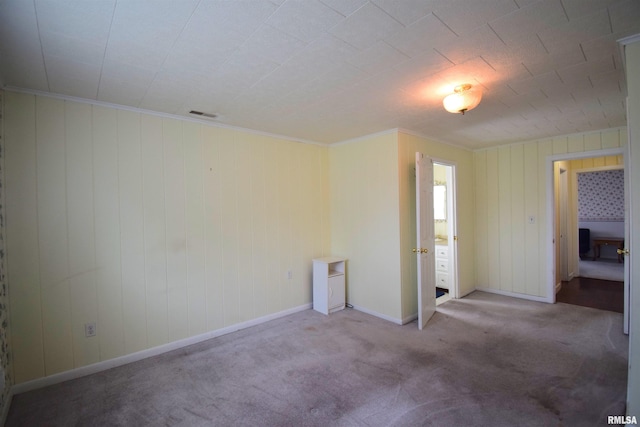 unfurnished bedroom featuring carpet and wooden walls