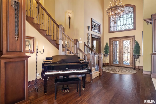 entrance foyer featuring a high ceiling, a chandelier, french doors, and hardwood / wood-style flooring