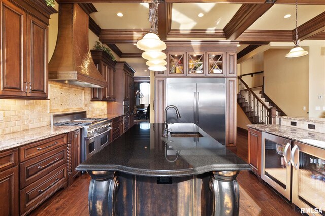 kitchen featuring premium range hood, premium appliances, dark wood-type flooring, and sink