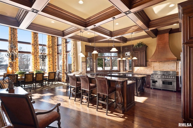 bar featuring pendant lighting, premium range hood, stone counters, dark hardwood / wood-style floors, and range with two ovens