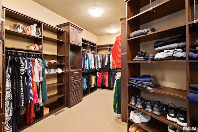 walk in closet featuring visible vents and light colored carpet