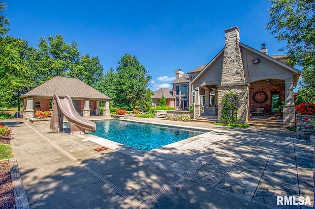 view of swimming pool with a patio and a water slide