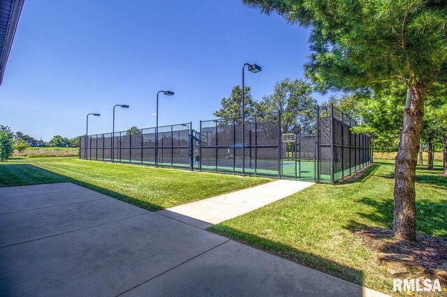 view of tennis court featuring a lawn