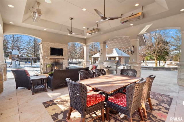 view of patio with area for grilling, outdoor dining space, an outdoor living space with a fireplace, a grill, and ceiling fan