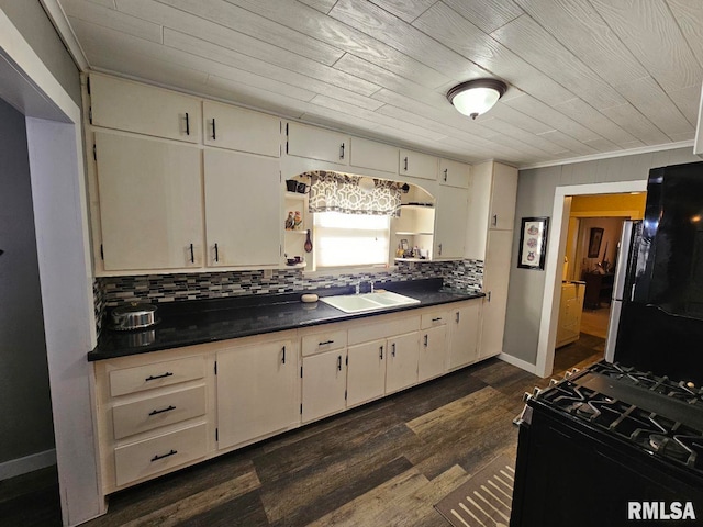 kitchen with backsplash, cream cabinets, black range with gas stovetop, and dark wood-type flooring