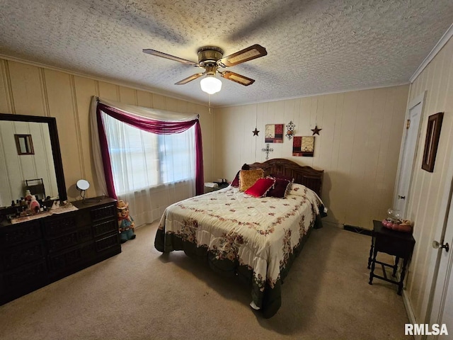 bedroom with ceiling fan, carpet floors, and a textured ceiling