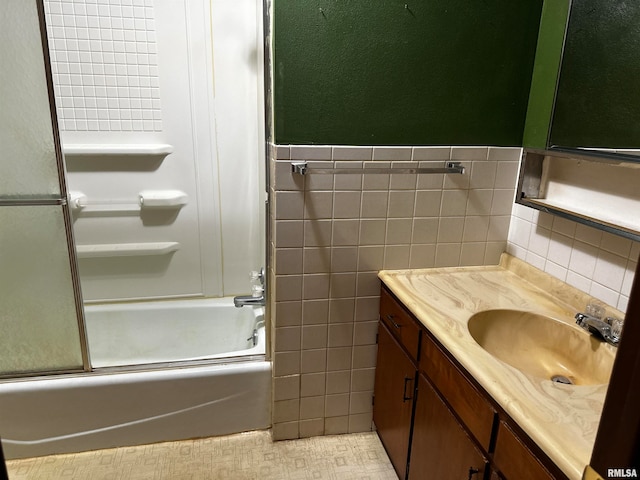 bathroom with tile walls, tile patterned flooring, vanity, and combined bath / shower with glass door