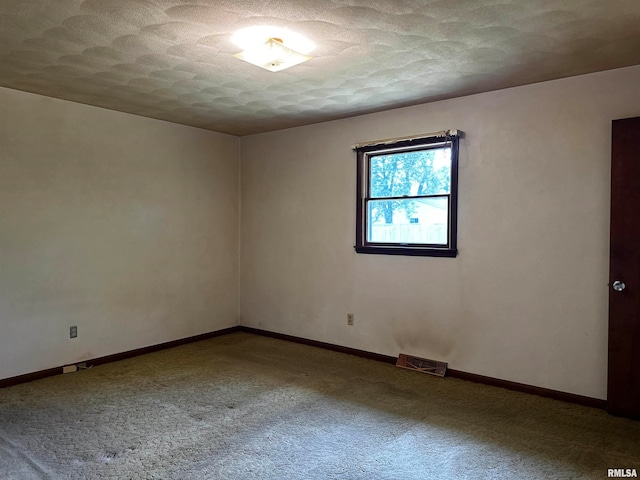 spare room featuring a textured ceiling and carpet flooring