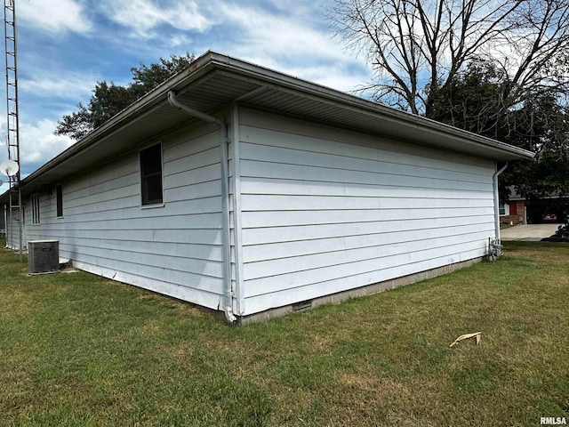 view of side of home with a yard and central AC