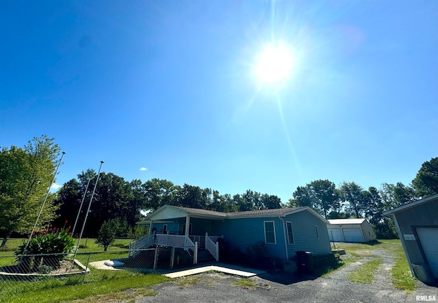 view of front of house featuring an outdoor structure, a garage, and a front yard