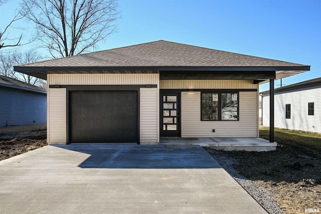 view of front of house with a garage, roof with shingles, and driveway